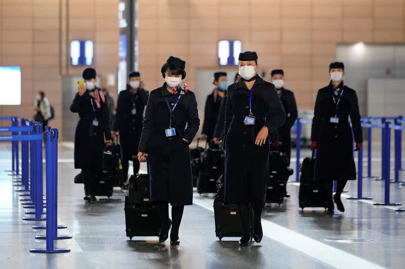 Flight crew members wear masks at the Pudong International Airport in Shanghai