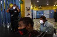 Donny Joubert, left, vice president of Watts Gang Task Force, puts on a face mask while waiting for volunteers to arrive before a community event as he is joined by Kevin Hunt, foreground, and Hank Henderson at the Nickerson Gardens housing project in the Watts neighborhood of Los Angeles, Wednesday, June 10, 2020. Donny Joubert remembers the chaos of 1965 through the eyes of a 5-year-old. Smoke filled the air, adults wept in front of a black and white TV to images of their community burning and widespread looting and Joubert thought his little plastic army soldiers had come to life. (AP Photo/Jae C. Hong)