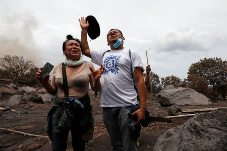 People pray in an affected area after the eruption of the Fuego volcano in Escuintla, Guatemala, June 8, 2018. REUTERS/Carlos Jasso