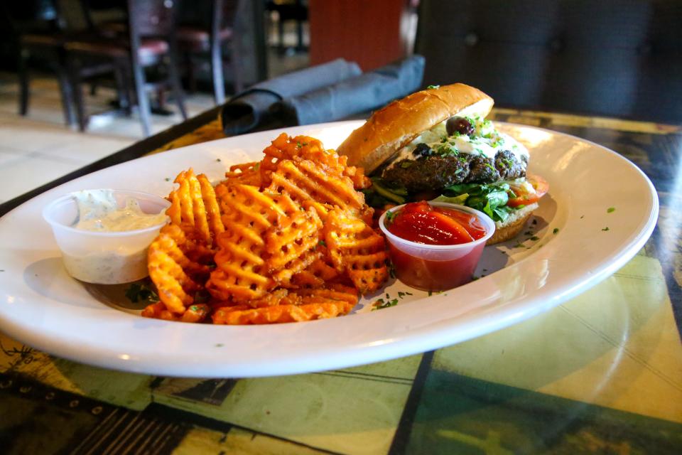 The Lamb Burger is Ginger Café & Grill's signature hamburger. It contains ground lamb mixed with special spices, feta cheese, tzatziki, tomatoes and olives.