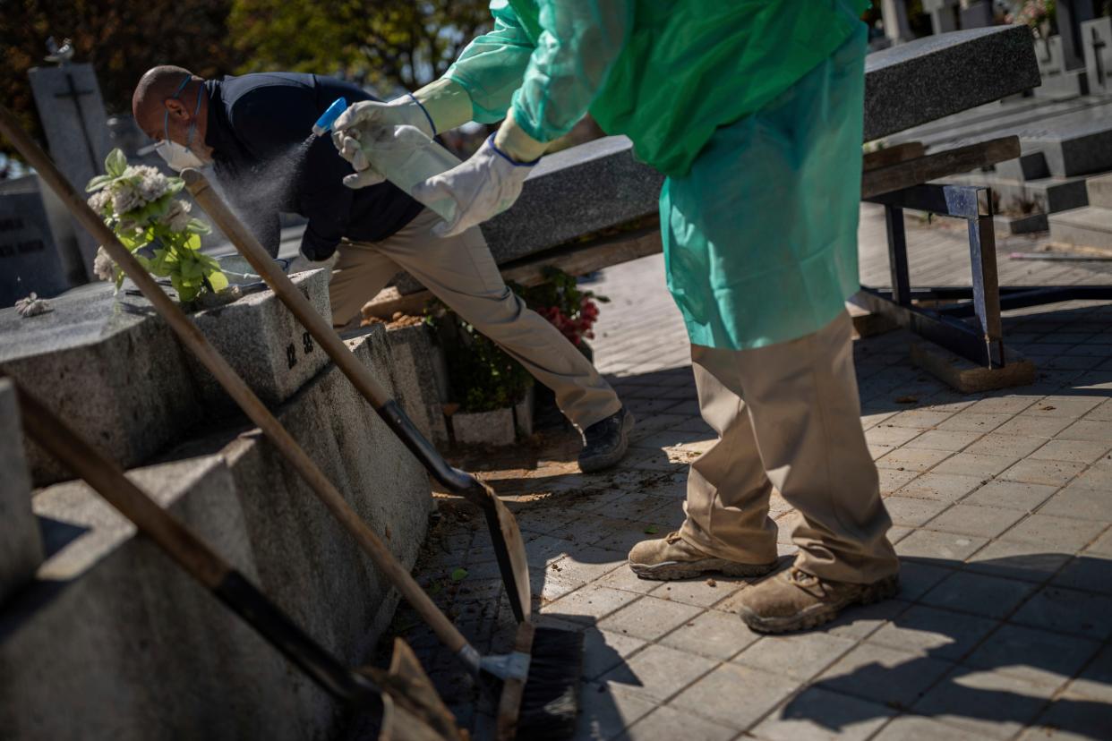 An undertaker disinfects tools with a homemade sanitiser during the coronavirus outbreak at a cemetery in Madrid, Spain, on Thursday, March 25, 2020.