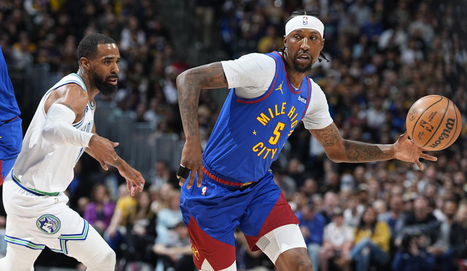 Denver Nuggets guard Kentavious Caldwell-Pope, right, drives to the basket as Minnesota Timberwolves guard Mike Conley defends in the first half of an NBA basketball game Friday, March 29, 2024, in Denver. (AP Photo/David Zalubowski)