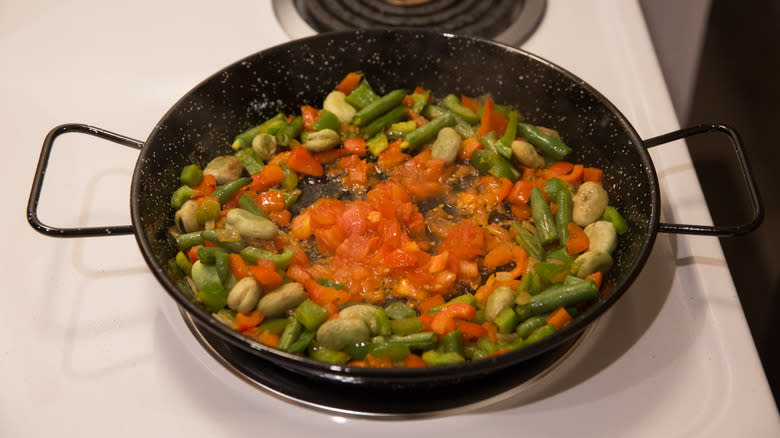 vegetable paella cooking on stove