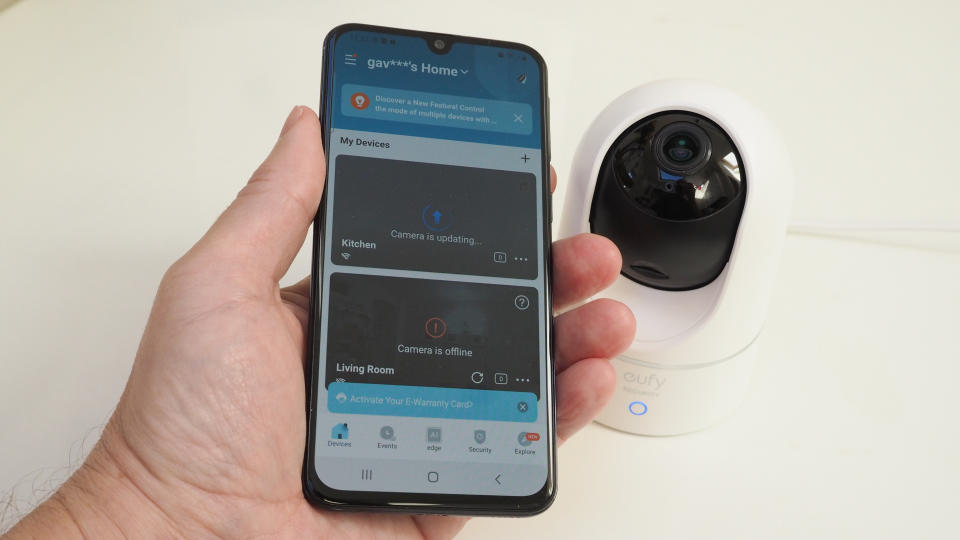 Phone held in a hand showing the app for a Eufy Indoor Cam E220