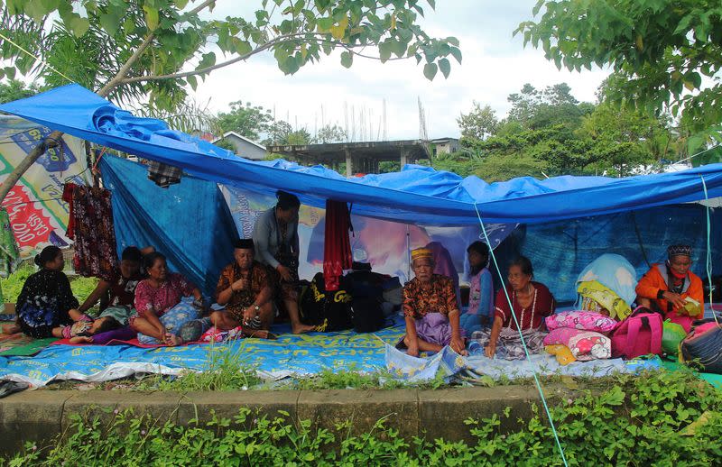 Locals who fled to higher ground are seen at a temporary shelter following an earthquake in Mamuju