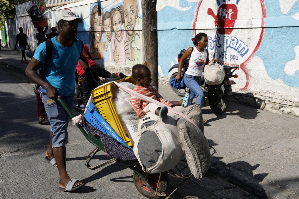 Residents flee their homes during clashes between police and gang member, in Port-au-Prince, Haiti, Saturday, March 9, 2024. (AP Photo/Odelyn Joseph)