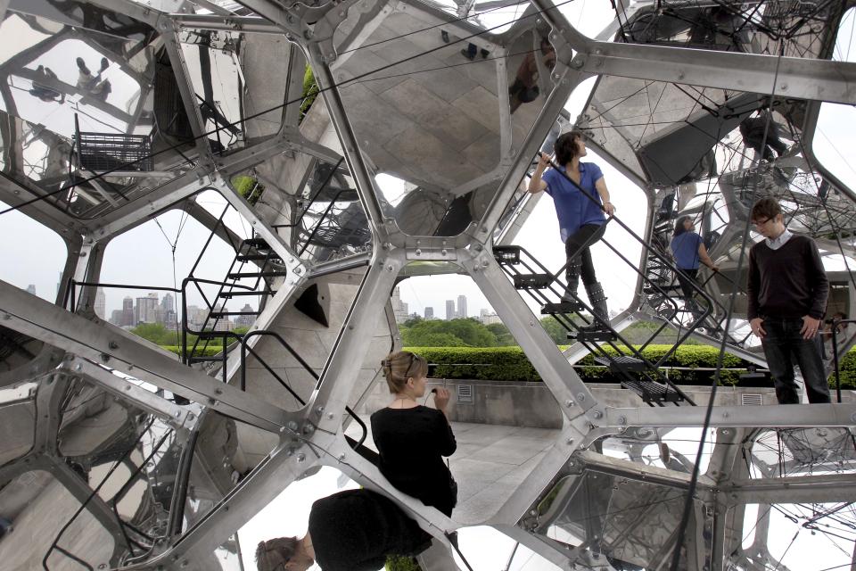 Visitors look at a structure by Tomas Saraceno called "Cloud City" during a media preview on the rooftop of the Metropolitan Museum of Art in New York, Monday, May 14, 2012. The maker of Cloud City, Argentine artist Tomas Saraceno, wants to provoke the feeling of being in a cloud floating in the middle of several realities. (AP Photo/Seth Wenig)