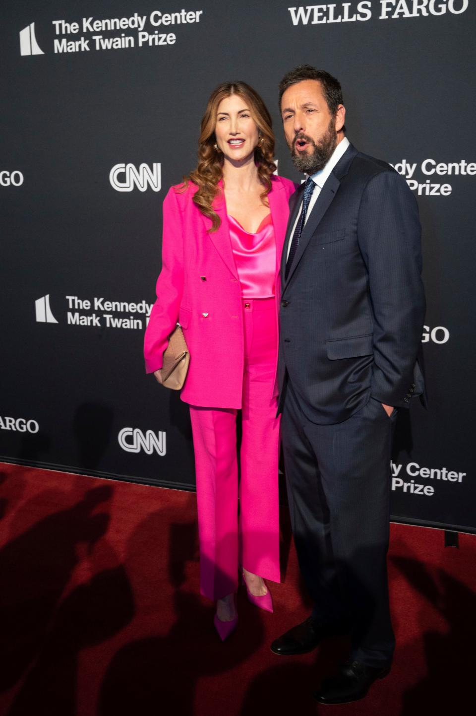 Mark Twain Prize recipient Adam Sandler, right, and his wife, Jackie Sandler, arrive on the red carpet at the start of the 24th Annual Mark Twain Prize for American Humor at the Kennedy Center for the Performing Arts on March 19, 2023.