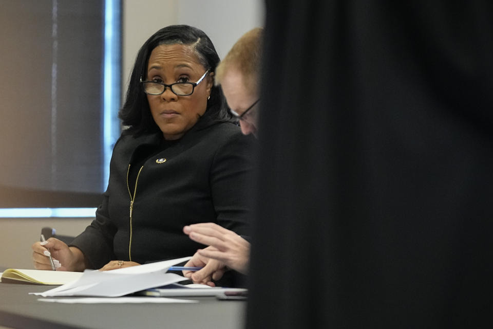 Fulton County District Attorney Fani Willis sits in a courtroom in the Fulton county courthouse, Tuesday, July 11, 2023, in Atlanta. A grand jury being seated Tuesday in Atlanta will likely consider whether criminal charges are appropriate for former President Donald Trump or his Republican allies for their efforts to overturn his 2020 election loss in Georgia. (AP Photo/Brynn Anderson)