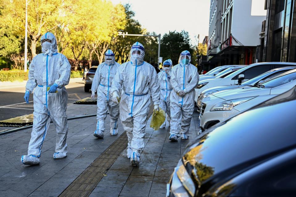 Health workers are seen near a residential area under lockdown due to Covid-19 coronavirus restrictions in Beijing on November 13, 2022. (Photo by Noel CELIS / AFP) (Photo by NOEL CELIS/AFP via Getty Images)