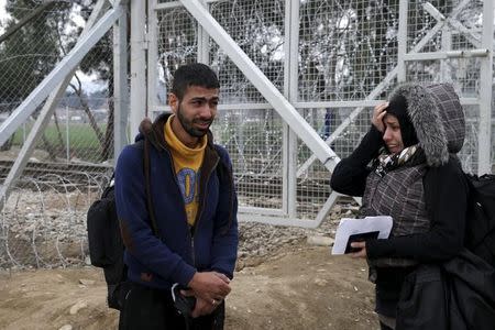 Migrants cry next to a border fence at the Macedonian-Greek border in Gevgelija, Macedonia February 24, 2016. REUTERS/Marko Djurica