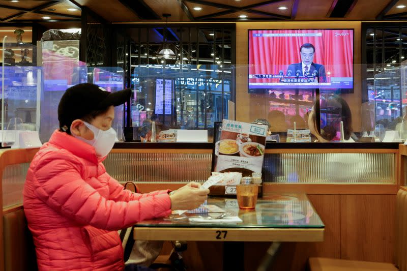 A TV screen showing news over the opening session of the National People's Congress (NPC), is seen in Hong Kong