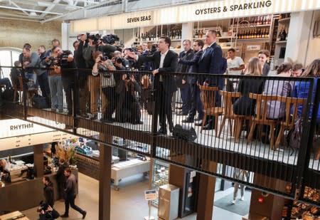 Ukraine's President Volodymyr Zelenskiy waves to audience as he holds a press-marathon at a food market in Kiev