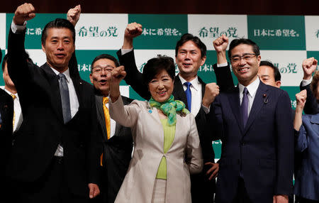 Tokyo Governor Yuriko Koike (C), the leader of her new Party of Hope, raises her fist with her party members, including Goshi Hosono (L), a former environment minister and Masaru Wakasa (R of Koike), a former prosecutor who left the ruling Liberal Democratic Party, during a news conference to announce the party's campaign platform in Tokyo, Japan, September 27, 2017. REUTERS/Issei Kato