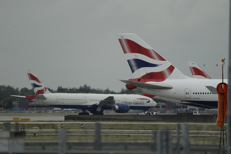 A British Airways plane, at left, is towed past other planes sitting parked at Heathrow Airport in London, Monday, Sept. 9, 2019. British Airways says it has had to cancel almost all flights as a result of a pilots' 48-hour strike over pay. (AP Photo/Matt Dunham)