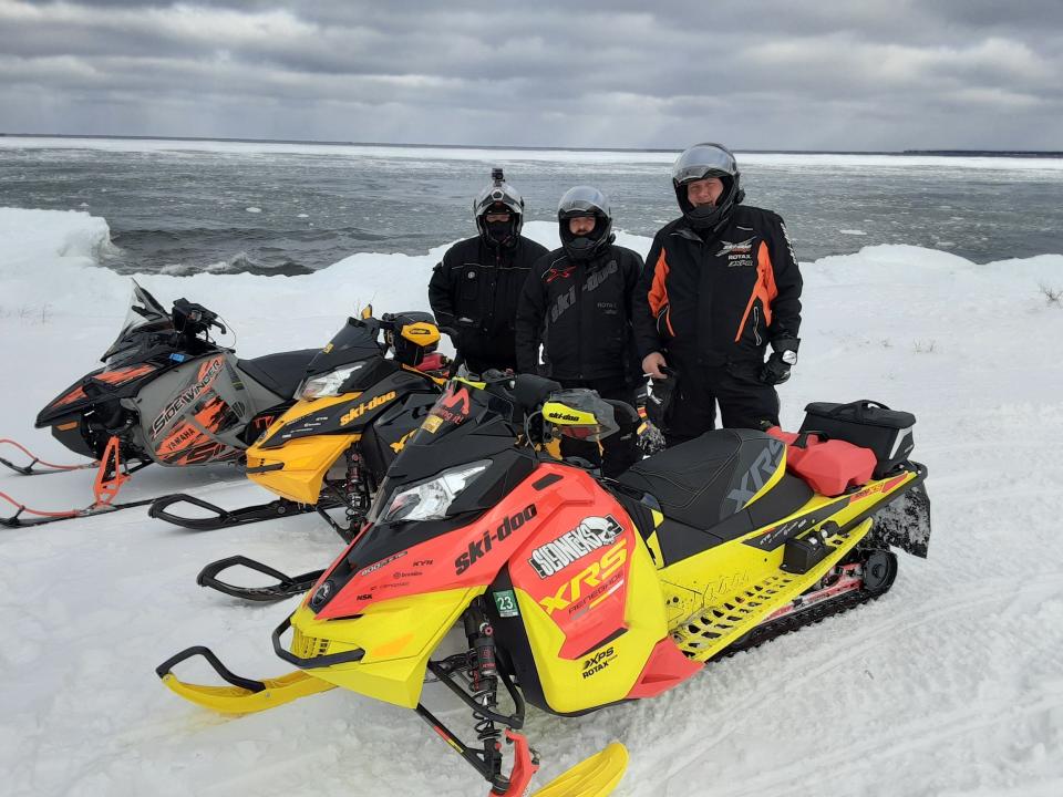 Members of the Snowbusters Snowmobile Club stop along the Lake Superior shore during a trip to Michigan's Upper Peninsula.