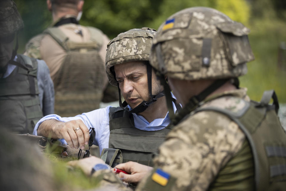 Ukrainian President Volodymyr Zelenskiy talks with servicemen as he visits the war-hit Luhansk region, eastern Ukraine, Monday, May 27, 2019. (Ukrainian Presidential Press Office via AP)