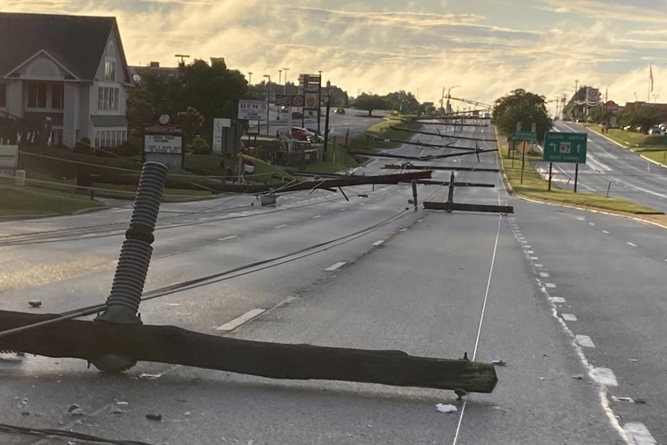 Fallen power poles lie along Route 140 in Westminster, Md., on Monday, Aug. 7, 2023. (Baltimore Sun Staff/The Baltimore Sun via AP)