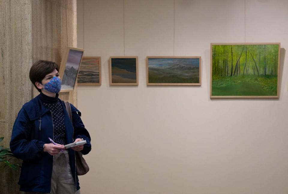 Journal reporter Amy Russo checks out the work of artist David Everett at the Bank RI Gallery in downtown Providence on Gallery Night Providence.