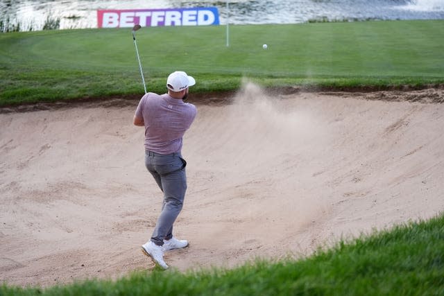 Tyrrell Hatton hits a bunker shot on the 18th