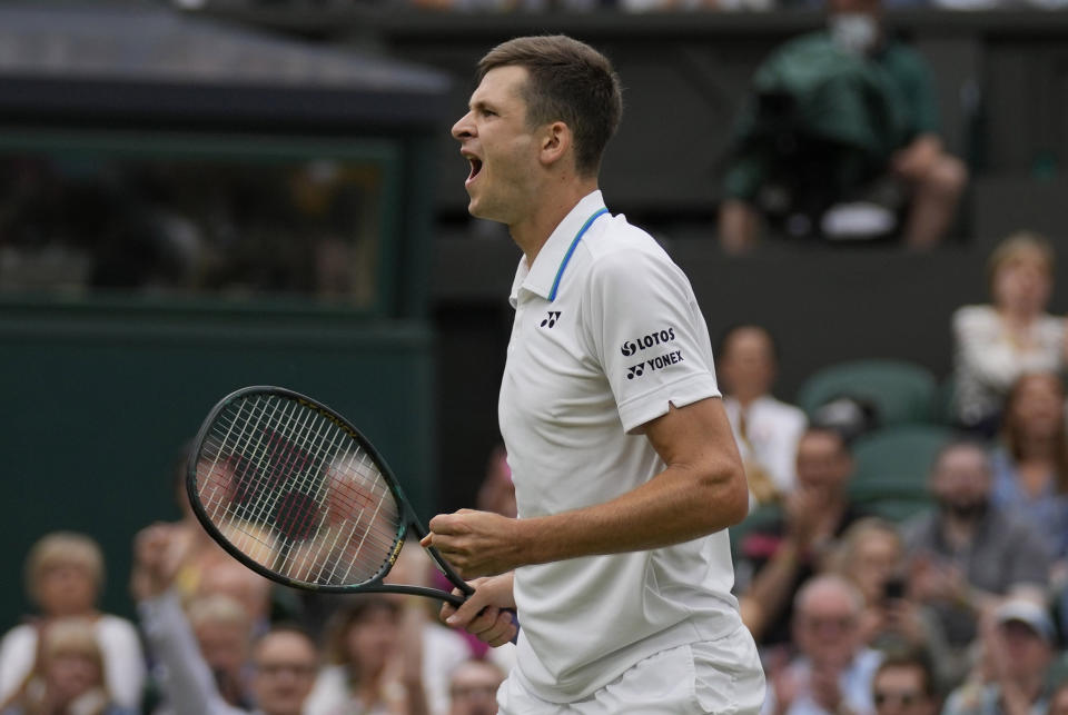 Poland's Hubert Huekacz celebrates after defeating Russia's Daniil Medvedev during the men's singles fourth round match on day eight of the Wimbledon Tennis Championships in London, Tuesday, July 6, 2021. (AP Photo/Kirsty Wigglesworth)