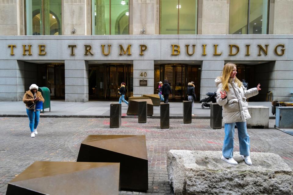 People stand outside of 40 Wall Street, also known as ‘the Trump Building’, on 12 February 2024 in New York City (AFP via Getty Images)