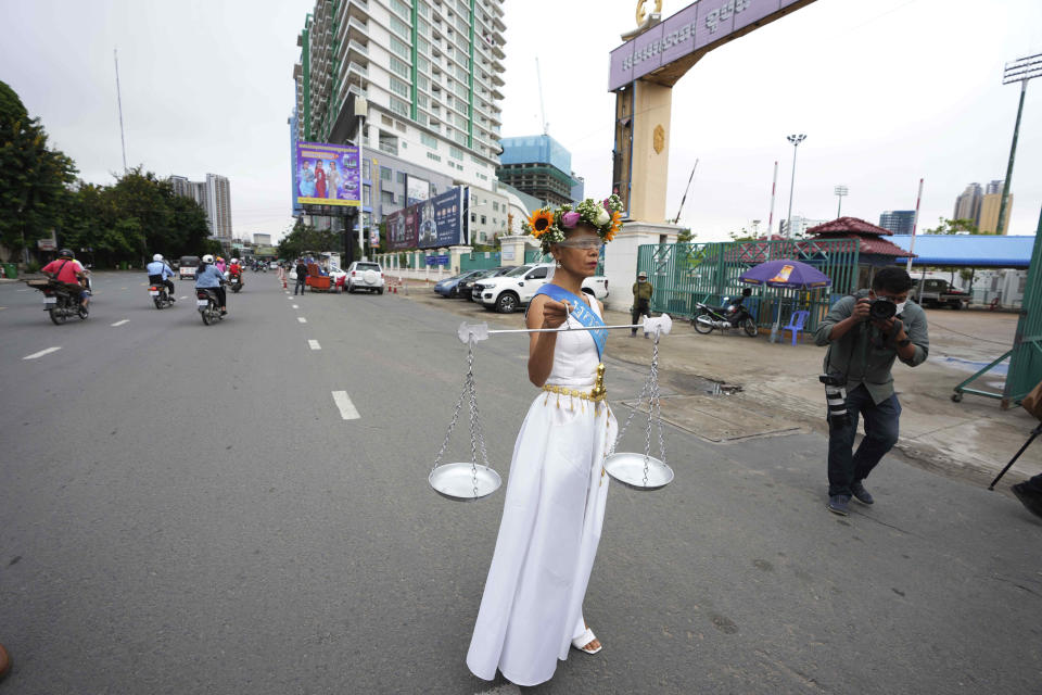 Cambodian-American lawyer Theary Seng, dressed in a pageant costume that reads "Lady Justice", walks outside Phnom Penh Municipal Court in Phnom Penh, Cambodia, Tuesday, May 3, 2022. Tuesday is the the final day of hearings for her trial on treason and a related charge for which she could receive a prison sentence of up to 12 years. (AP Photo/Heng Sinith)