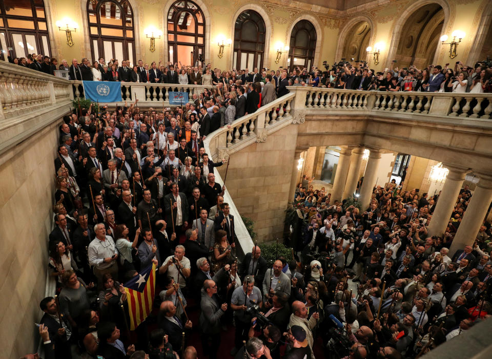 Catalan government members, pro-independence deputies and mayors from pro-independence towns sing the Catalan anthem after the regional parliament voted to declare independence.