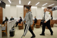 Former Marjory Stoneman Douglas High School student Anthony Borges, who was injured in the 2018 shootings, enters the courtroom with his father, Royer Borges, to testify during the trial of former Marjory Stoneman Douglas High School School Resource Officer Scot Peterson, Thursday, June 8, 2023, at the Broward County Courthouse in Fort Lauderdale, Fla. Peterson is charged with child neglect and other charges for failing to stop the Parkland school massacre five years ago. (Amy Beth Bennett/South Florida Sun-Sentinel via AP, Pool)