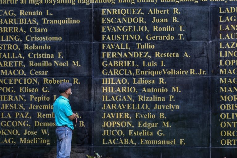 Former political prisoner Bonifacio Ilagan looks at the "Wall of Remembrance" showing names of victims from the martial law era under former dictator Ferdinand Marcos (AFP/JAM STA ROSA)