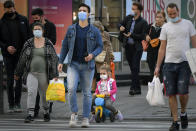 A girl wears a face mask for protection against COVID-19 infection while crossing a street in Bucharest, Tuesday, Oct. 20, 2020. Local authorities imposed the use of face masks in all public spaces, indoors and outdoors, closed schools, restaurants, theatres and cinemas after the rate of COVID-19 infections went above 3 cases per 1000 inhabitants in the Romanian capital Bucharest. (AP Photo/Andreea Alexandru)