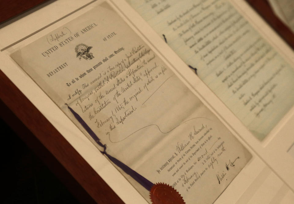 FILE - In this Tuesday, June 3, 2014 file photo, a duplicate of the 13th Amendment appears on display at the North Carolina Department of Cultural Resources in Raleigh, N.C. As the nation on Thursday, June 17, 2021 officially made Juneteenth a federal holiday, honoring when the last enslaved Black people learned they were free, lawmakers are reviving calls to end a loophole in the Constitution that has allowed another form of slavery to thrive. (AP Photo/Gerry Broome)