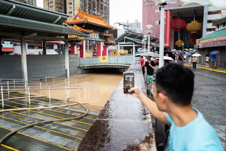 Un toma una fotografía de una zona inundada en el centro de Hong Kong