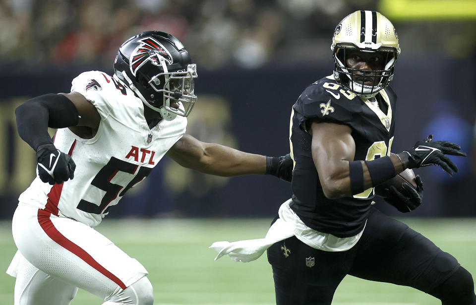 NEW ORLEANS, LOUISIANA – JANUARY 07: Juwan Johnson #83 of the New Orleans Saints runs the ball by Andre Smith #59 of the Atlanta Falcons in the first half at Caesars Superdome on January 07, 2024 in New Orleans, Louisiana. (Photo by Chris Graythen/Getty Images)