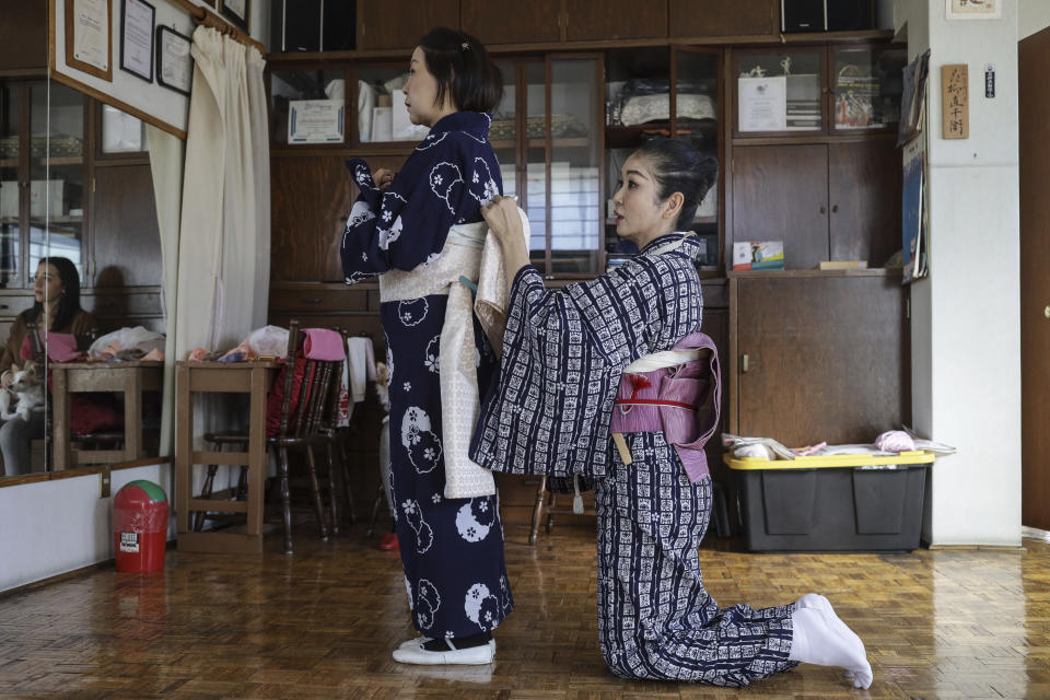Professor Naoko Kihara adjusts the sash of her disciple Eiko Moriya, in her dance studio in Mexico City, Friday, Nov. 24, 2023. Kihara won’t reveal her age, but she’s been practicing the Japanese traditional Hanayagi-style dance for almost 24 years. (AP Photo/Ginnette Riquelme)