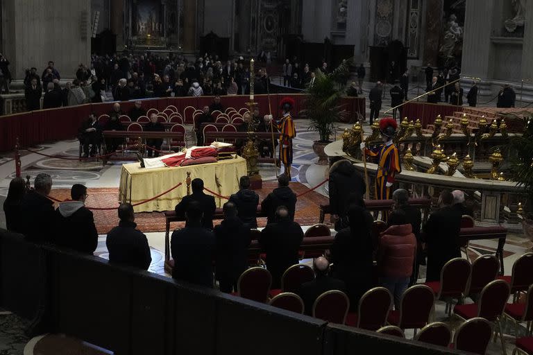 La gente mira el cuerpo del difunto Papa Emérito Benedicto XVI expuesto en el interior de la Basílica de San Pedro en el Vaticano, el lunes 2 de enero de 2023. Benedicto XVI, el teólogo alemán que será recordado como el primer Papa en 600 años en renunciar, ha muerto, anunció el Vaticano el sábado. Tenía 95 años. (Foto AP/Alessandra Tarantino)