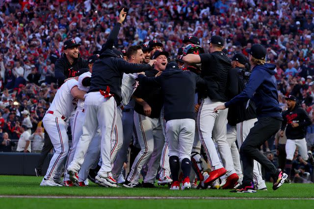 <p>Adam Bettcher/Getty</p> Minnesota Twins players celebrate after first postseason series victory in 21 years