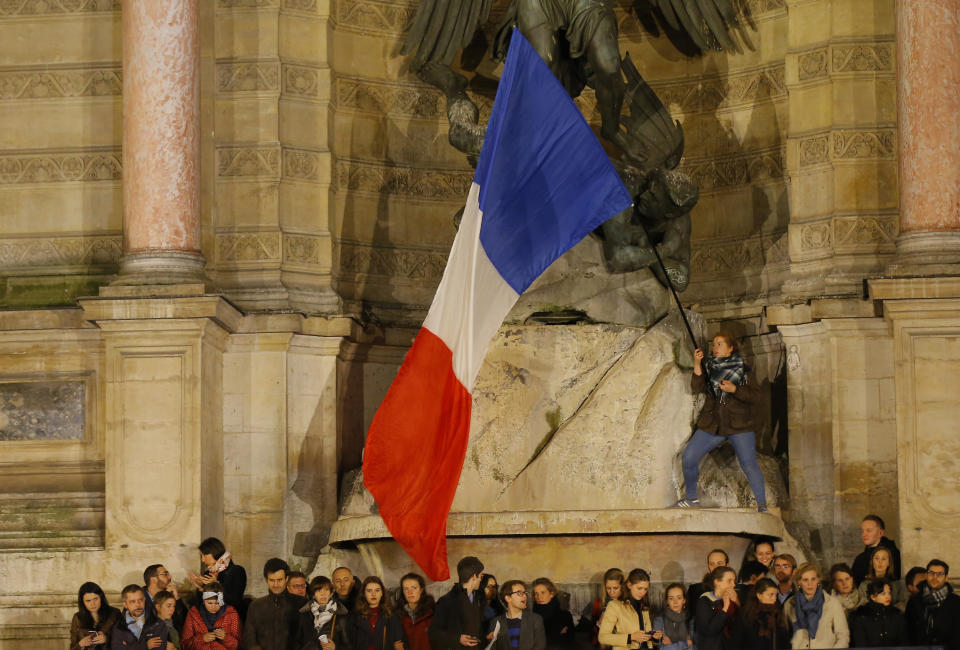 People attend a vigil in Paris, Tuesday April 16, 2019. Firefighters declared success Tuesday in a more than 12-hour battle to extinguish an inferno engulfing Paris' iconic Notre Dame cathedral that claimed its spire and roof, but spared its bell towers and the purported Crown of Christ. (AP Photo/Michel Euler)
