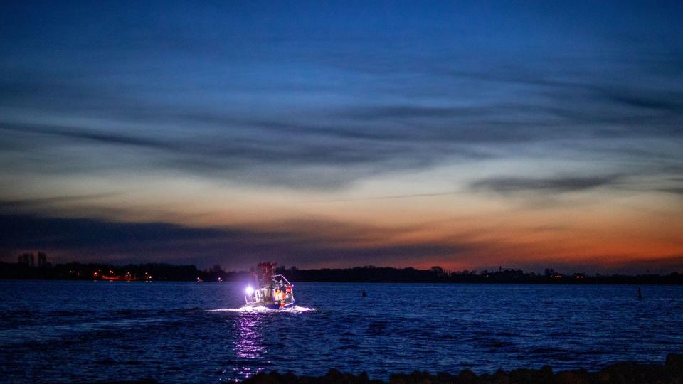 Fischer sind am frühen Morgen mit ihrem Kutter im Greifswalder Bodden unterwegs.