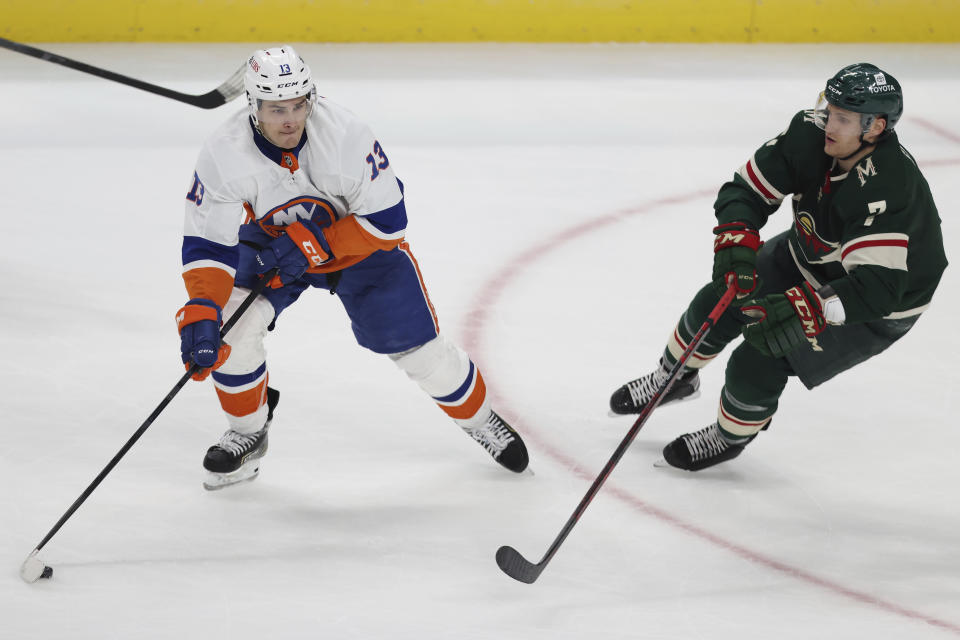New York Islanders' Mathew Barzal (13) handles the puck against Minnesota Wild's Nico Sturm (7) during the third period of an NHL hockey game Sunday, Nov. 7, 2021, in St. Paul, Minn. (AP Photo/Stacy Bengs)