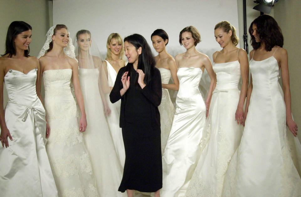 FILE - This May 1, 2001 file photo shows fashion designer Vera Wang with her models after a showing of Wang's wedding fashions at her showroom in New York. Wang, 63, was honored for her lifetime achievement by the Council of Fashion Designers at its star-studded awards show Monday night. She received the award from her former employer and mentor Ralph Lauren, and she received a standing ovation from her peers. (AP Photo/Louis Lanzano, file)