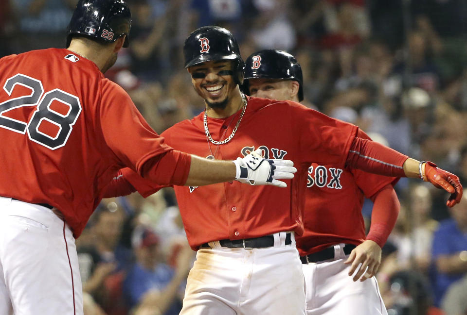 J.D. Martinez (left) and Mookie Betts (center) work on their secret handshake (AP Photo/Elise Amendola)