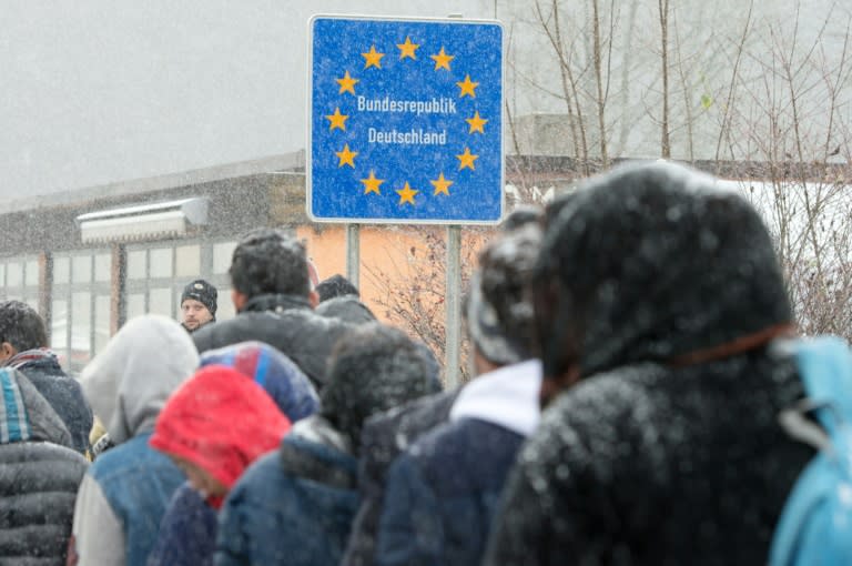 Migrants walk in line as they enter Germany via the Austrian border near Wegscheid, southern Germany, on November 21, 2015