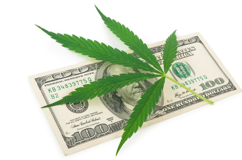 Marijuana leaf on top of a $100 bill