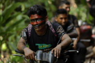 Tenetehara Indigenous man Gilberto Tembe waits on his motorcycle as fellow members of the Ka’Azar, or Forest Owners, clear away a tree felled by illegal loggers, as they patrol their lands on the Alto Rio Guama reserve in Para state, near the city of Paragominas, Brazil, Tuesday, Sept. 8, 2020. Three Tenetehara Indigenous villages are patrolling to guard against illegal logging, gold mining, ranching, and farming as increasing encroachment and lax government enforcement during COVID-19 have forced the tribe to take matters into their own hands. (AP Photo/Eraldo Peres)