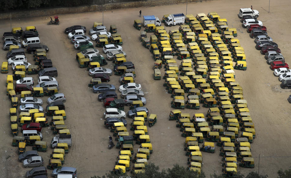 A rickshaw puller pedals past rows of auto-rickshaws and taxis parked during a public transport strike in New Delhi, India, Thursday, Sept. 19, 2019. Commuters in the Indian capital are facing problems as a large section of the public transport, including private buses, auto-rickshaws and a section of app-based cabs Thursday remained off the roads in protest against a sharp increase in traffic fines imposed by the government under a new law.(AP Photo/Manish Swarup)