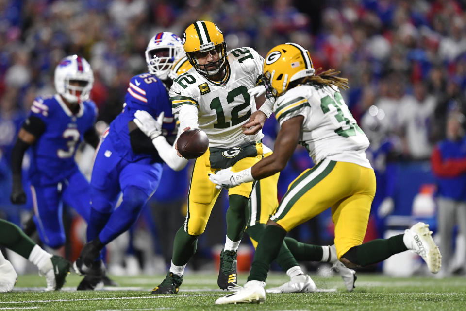 Green Bay Packers quarterback Aaron Rodgers (12) hands off the ball to running back Aaron Jones (33) during the first half of an NFL football game against the Buffalo Bills Sunday, Oct. 30, 2022, in Orchard Park. (AP Photo/Adrian Kraus)