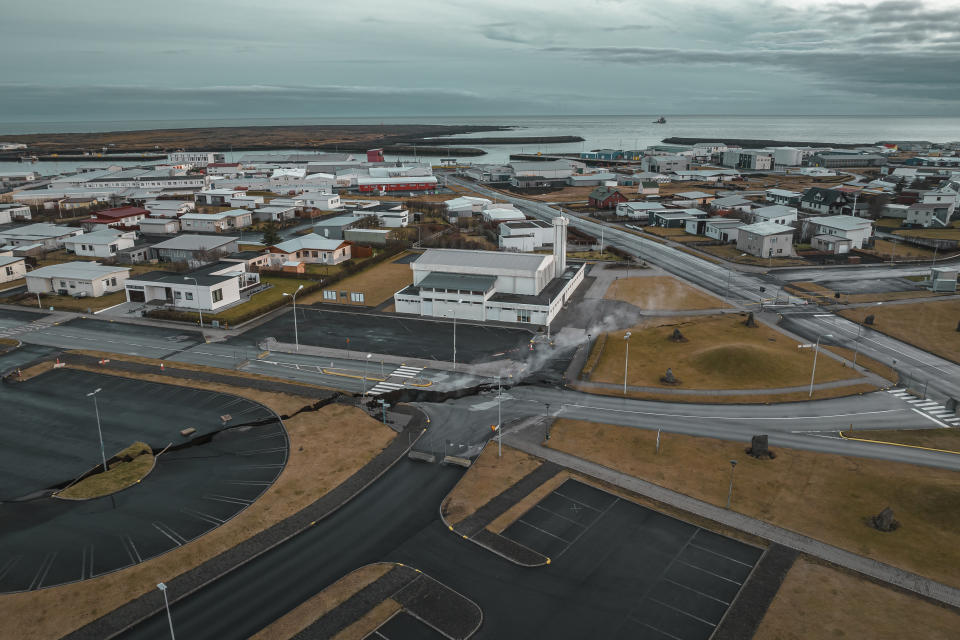 This image taken with a drone shows cracks on the road next to a church in the town of Grindavik, Iceland, Thursday, Nov. 16, 2023. Residents of a fishing town in southwestern Iceland have left their homes after increasing concern about a potential volcanic eruption caused civil defense authorities to declare a state of emergency in the region. Iceland's Meteorological Office says police decided to evacuate Grindavik after recent seismic activity in the area moved south toward the town. (AP Photo/Bjorn Steinbekk)