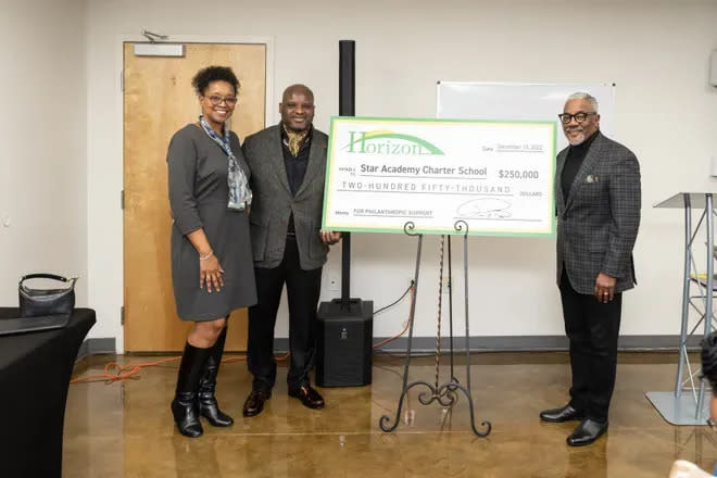 Preston Byrd (middle) and his wife present a $250,000 check to a Memphis area charter School in December.