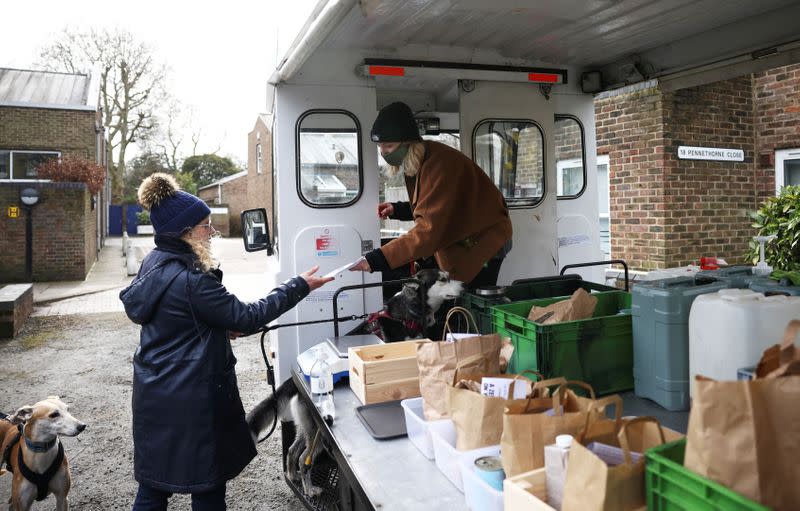 Ella Shone, serves a customer from her mobile zero waste shop called the 'Top Up Truck' in London